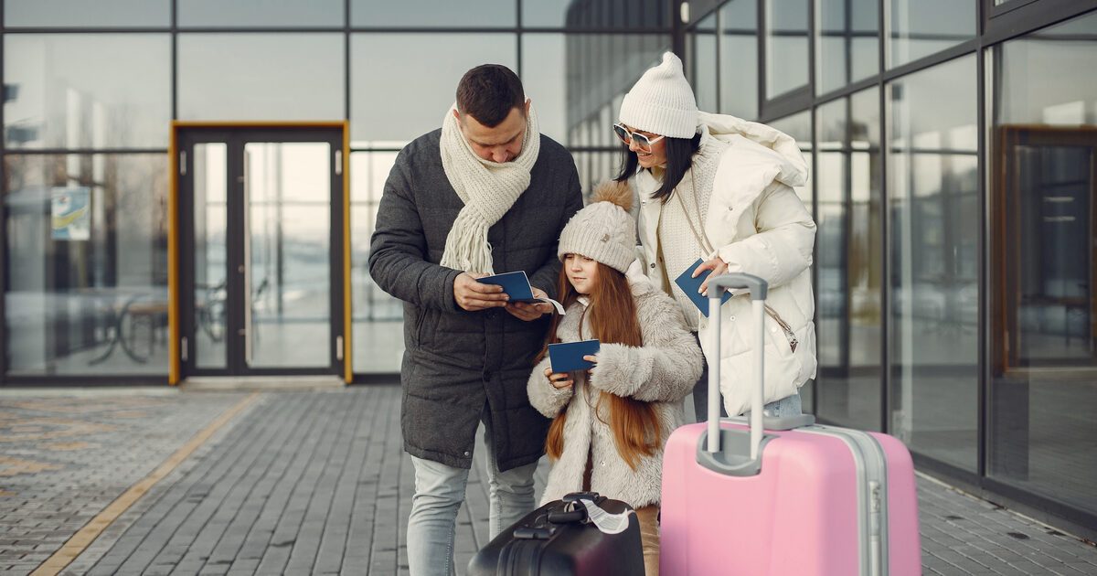 Familia revisando pasaportes con su equipaje antes de un viaje con un menor de edad